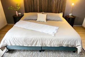 a large bed with white sheets and pillows on it at Luxury Villa In Aguacatala2 in Medellín