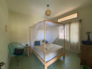 1 dormitorio con cama con dosel y silla en Beautiful 2 bedroom apartment, en Santa María Tonameca