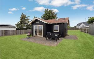 a black shed with chairs and a table in a yard at Gorgeous Home In Esbjerg V With House Sea View in Esbjerg