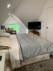 een slaapkamer met een bed en een flatscreen-tv bij Green Oaks B&B in Niagara on the Lake
