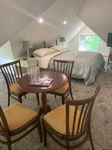 1 dormitorio con 1 cama, mesa y sillas en Green Oaks B&B, en Niagara on the Lake