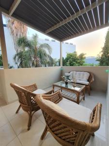 un patio con sedie in vimini e un tavolo sul balcone. di Livas City Relaxing Apartment a Città di Kos