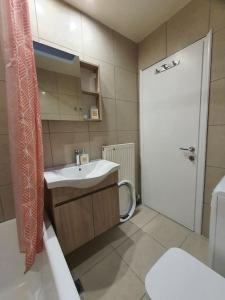 a bathroom with a sink and a toilet and a door at Livas City Relaxing Apartment in Kos
