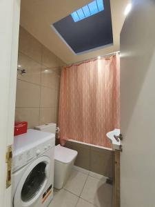a bathroom with a washing machine and a toilet at Livas City Relaxing Apartment in Kos Town