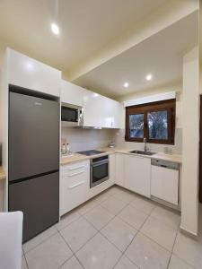 a kitchen with white cabinets and a black refrigerator at Livas City Relaxing Apartment in Kos Town