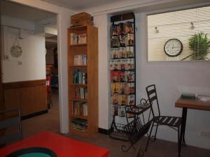 een kamer met een boekenplank gevuld met boeken bij Hôtel - Villa Les Sirènes in Argelès-sur-Mer
