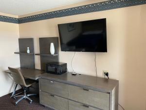 a room with a desk and a tv on a wall at Budget Inn of Sebring in Sebring