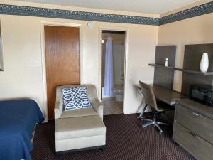 a hotel room with a bed and a desk and a chair at Budget Inn of Sebring in Sebring
