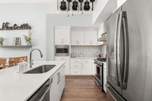 a kitchen with white cabinets and a stainless steel refrigerator at FarmHouse Vibe on Centennial w garage and billiards in Nashville