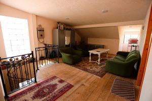 a living room with green chairs and a table at Guesthouse Gua in Kutaisi