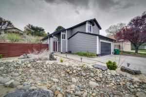 a house with a fence and a pile of rocks at Reno Getaway with Spacious Patio and Grill! in Reno