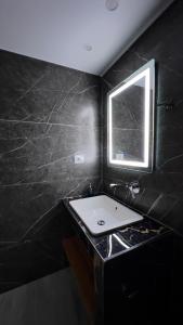 een zwarte badkamer met een wastafel en een raam bij Studios&Apartment Niko Luka in Ksamil