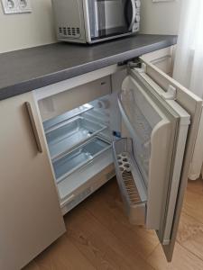 a refrigerator with its door open in a kitchen at Cēsu apartamenti in Cēsis