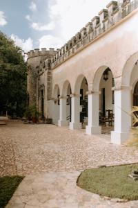 einen Innenhof eines Schlosses mit Bögen in der Unterkunft Hacienda Kaan Ac in Valladolid