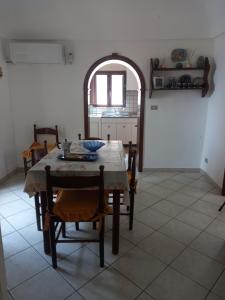 a dining room with a table and chairs in a room at La sartoria in Centuripe
