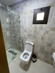 a bathroom with a toilet and a shower and a window at Résidence Colina Smir in M'diq +4 photos