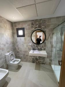 a bathroom with a toilet and a sink and a mirror at Résidence Colina Smir in M'diq