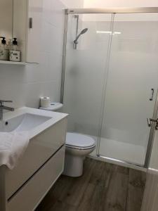 uma casa de banho branca com um WC e um chuveiro em Casa particular en Renedo de Cabuérniga em Renedo