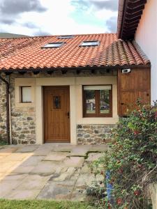 a house with a wooden door and a brick at Casa particular en Renedo de Cabuérniga in Renedo