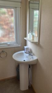 a bathroom with a white sink and a mirror at 2 Bedroom 6 berth Caravan Towyn Rhyl in Rhyl