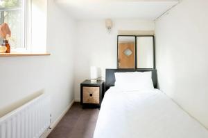 Giường trong phòng chung tại Garden flat on leafy Cator Estate in Blackheath