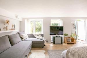 a living room with a couch and a tv at Garden flat on leafy Cator Estate in Blackheath in London