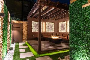 a pergola with a couch and a fireplace in a yard at Alexandras Palace in Bradford