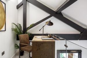an office with a desk with a lamp and a chair at Stunning Designer Penthouse - 85'' Cinema TV! in Bradford