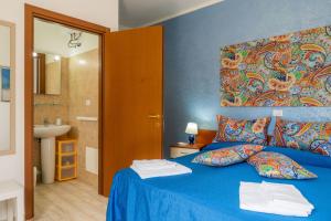 1 dormitorio con cama azul y baño en Villa Elisa, en Torre Lapillo