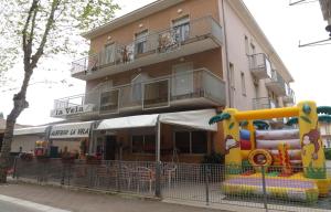 a apartment building with a playground in front of it at Hotel La Vela in Bellaria-Igea Marina