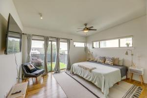 een slaapkamer met een bed, een stoel en ramen bij Modern Austin Vacation Rental with Covered Patio in Austin