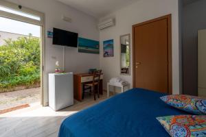 Un dormitorio con una cama, un escritorio y un televisor. en Villa Elisa, en Torre Lapillo