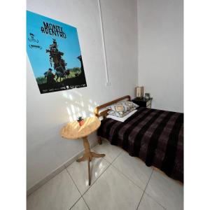 ein Schlafzimmer mit einem Bett und einem Plakat an der Wand in der Unterkunft Hostal Mamaquilla in Pasto