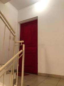 a red door in a room with a staircase at Las chismosas in Santiago del Estero