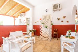 sala de estar con sillas blancas y mesa en Villa Elisa, en Torre Lapillo