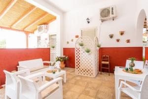 a living room with white chairs and a table at Villa Elisa in Torre Lapillo