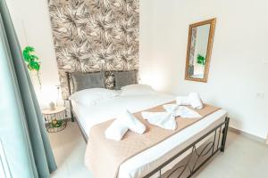 una camera da letto con un letto con lenzuola bianche e uno specchio di City Apartment 58 - 5min to Kos Beach a Città di Kos