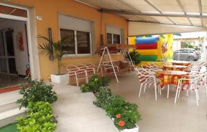 een patio met een tafel en stoelen in een gebouw bij Hotel La Vela in Bellaria-Igea Marina