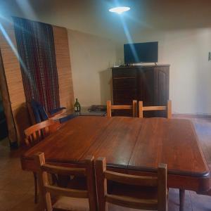 a wooden table with chairs and a television on top at MONOAMBIENTE BOMBAL in San Rafael