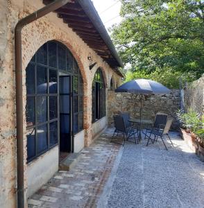 a patio with a table and an umbrella at Casavacanzepisa in San Giuliano Terme