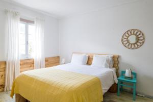 um quarto com uma cama com um cobertor amarelo e um espelho em Casa Cabanas Ponta Delgada em São Roque
