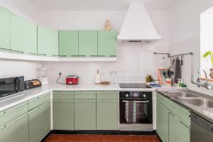 uma cozinha com armários verdes e um lavatório em Casa Cabanas Ponta Delgada em São Roque
