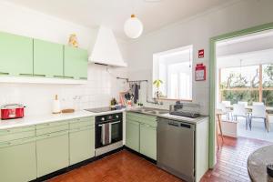 uma cozinha com armários verdes e uma bancada em Casa Cabanas Ponta Delgada em São Roque