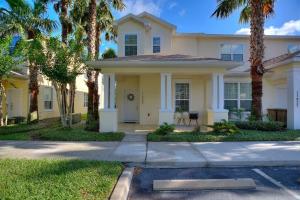 a yellow house with palm trees in front of it at Placid Retreat Near Disney Orlando, FL in Orlando