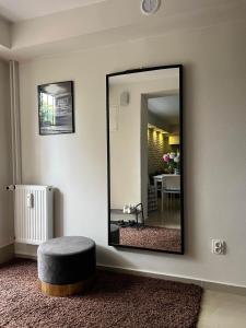 a mirror in a room with a stool and a table at Apartament Kwaskowa Góra in Kazimierz Dolny