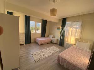 a bedroom with two beds and a window at Azize in Fethiye