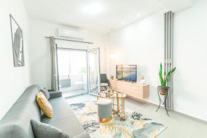 ein Wohnzimmer mit einem Sofa und einem TV in der Unterkunft City Apartment 58 - 5min to Kos Beach in Kos-Stadt