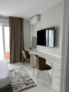 a white bedroom with a desk and a tv on a wall at Luxury beach flat in Alicante