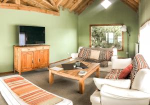 ein Wohnzimmer mit einem Sofa und einem Tisch in der Unterkunft Hosteria La Estepa in El Calafate