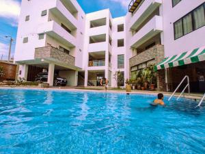 a boy in a swimming pool in front of a building at Hotel Campestre Casa Laredo in Chao